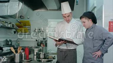 主厨拿着菜谱，向他的年轻学员解释一些事情